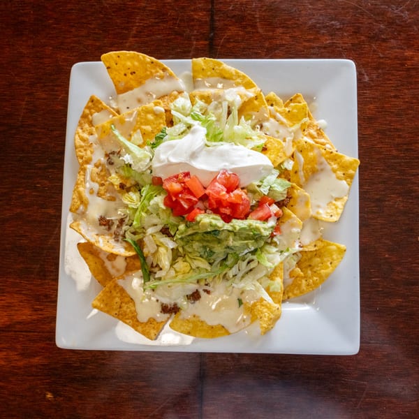Tacos A La Diabla nachos with cheese, ground beef, lettuce, tomatoes, guacamole, and sour cream.