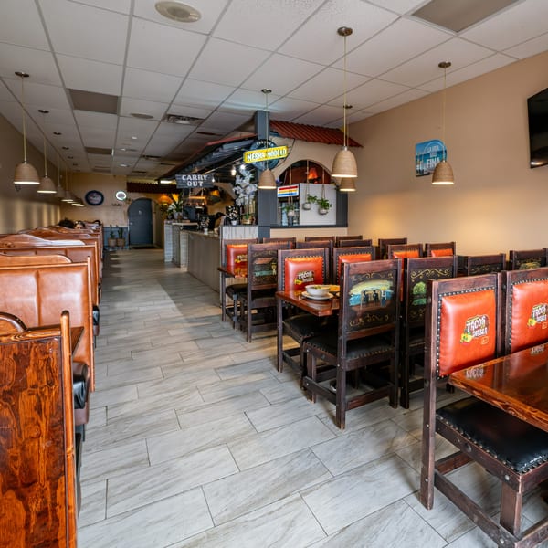 Interior of Tacos A La Diabla restaurant with empty tables, chairs, and booths, featuring Mexican decor.